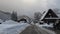 Drive on plowed road through snowy mountain village with historic houses