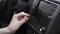 The driver adjusting the volume of a radio inside a car. Action. Close up of a woman hand with yellow manicure turning