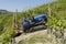 Driver on crawler tractor, climbs steeply up into the vineyards