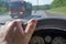 Driver hand on the steering wheel of a car and a passing truck