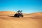 Driver in helmet ride buggy quad bike at Al awir sand dunes