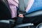driver in passenger compartment with fastened seat belt. Closeup of fixed seat belt buckle