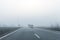 Driver POV on almost empty blue foggy misty rainy highway intercity road with low poor visibility on cold spring autumn