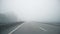Driver POV of empty grey foggy misty rainy highway intercity road with low poor visibility on cold spring ar autumn
