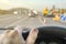 Driver`s hand on the steering wheel of a car that passes through the repaired section of the road