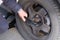 Driver is screwing and unscrewing changing car wheel by wrench. Damaged car tyre. Change a flat car tire on road. Auto repair