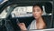 Driver smartphone sitting car wheel looking window closeup. Chic woman scrolling