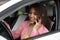 Driver woman driving a car distracted on the phone and looking at side