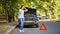 Driver woman in front of wrecked car in car accident. Scared woman in stress holding her head after auto crash calling to auto