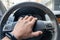 Drivers hand on a steering wheel of a car