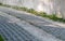 Driveway alongside concrete wall with gravel and lawn grid stones