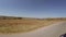 Driving along foothill country road on sunny midday. View of nearby lake and fields . Camera is in steadycam.