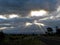 Driving in Australian countryside by sun rays through cloud gaps