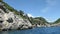 Driving with a boat from Paleokastritsa to Liapades beach at Corfu Island Greece. passing by sediment chalk rocks in the water.