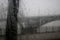 Driving a car under the bridge in heavy rain. Road, traffic, lights, crossing bridges view through the car window. Rain drops on