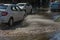 Driving cars on a flooded road during floods caused by rain storms. Cars float on water, flooding streets. Splash on the machine.