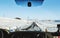 Driving on the country road in winter. Looking through car front windscreen, frozen road with snow covered and clear blue sky in I