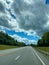 Driving on an deserted highway empty road heading into cloudy storming weather