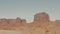 Driving On Dusty Dirt Road In Desert Among Red Rocks Buttes Of Monument Valley