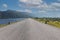 Driving on an empty road. Empty asphalt road through the green field and clouds on blue sky in summer day. Open road ahead, endles