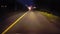 Driving Long Road at Night With Oncoming Vehicle Flashing High Beams.  Driver Point of View POV of Car Using High Beam Signal