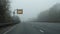 Driving motorway in fog. Stay home sign. Travel restrictions