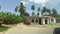 Driving Past Slums and Villages with Dilapidated Houses among Palm Trees, Africa