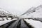 Driving on the road in Tibet, with snow mountain surrounding, no people and wild