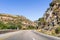 Driving on the scenic Highway 1 through a canyon in Santa Barbara County; metal mesh netting to prevent rock falling due to