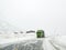 Driving through snowy road landscape, Norway. Green truck in front