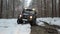 Driving SUV 6x6 by the off-road in the winter forest, front view. Off-road