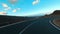 Driving vehicle on a long asphalt straight road in the nature with blue sky and horizon in background. Concept of travel and