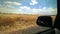 Driving, viewing the scenery from the vehicle, dry paddocks, blue sky and white floaty clouds