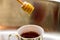 Drizzling honey into a hot beverage