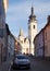 Drlicov Street, view of the sunlit Church of the Nativity of the Blessed Virgin Mary in the perspective, Pisek, Czechia