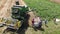 Drohobych, Ukraine - 04 July, 2018: Aerial view of combine harvester winnowing wheat into big bag held by people. Harvesting