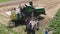 Drohobych, Ukraine - 04 July, 2018: Aerial view of combine harvester winnowing wheat into big bag held by people. Harvesting