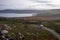 Drone aerial panoramic view of a camper van in green and red landscape with atlantic ocean in Tourinan Cape in Galicia, Spain