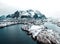 Drone aerial shots, photos in Henningsvaer, Lofoten Norway during cloudy weather winter time with snowy epic mountains