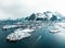 Drone aerial shots, photos in Henningsvaer, Lofoten Norway during cloudy weather winter time with snowy epic mountains
