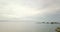 Drone aerial almost still shot showing birds on a rock and with dangerous stormy clouds over the calm sea