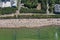 Drone aerial top down view on sunny beach with sunbathers with windbreaks and towels at sea in touristic city