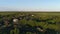 Drone aerial video panorama of Village with houses and gardens on a river surrounded by dense green forest with stunning