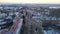 Drone aerial view of car traffic on road passing through town and roundabout at winter cloudy day