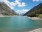 Drone aerial view of the Lake Livigno with with pedal boats. Italian Alps. Italy
