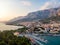 Drone aerial view of Makarska city, Croatia. Sunset over the city, beach and se. Biokovo mountains in the background. Summer time