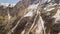 Drone aerial view of remaining snow of the avalanche fall from the mountains peaks in winter