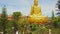 Drone Approaches Giant Buddha Sculpture among Tropical Trees