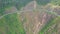 Drone approaches mountain highway curve on steep cliff