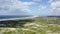 Drone, arid hill landscape and ocean in nature, summer and sky background with horizon, grass and earth. Environment